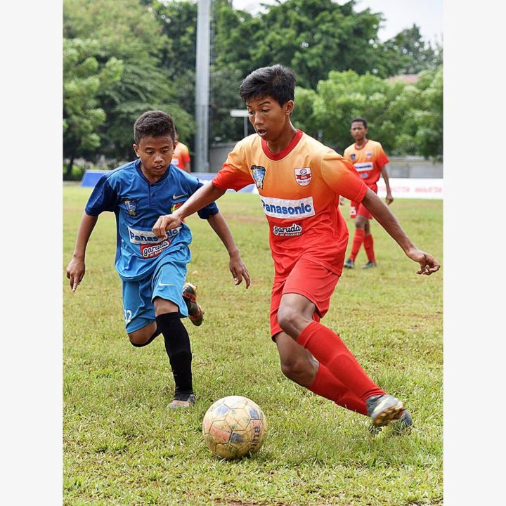 Pemain SSB Cibinong Raya (biru) dan SSB Ragunan Soccer School (oranye) berebut bola dalam laga pekan ke-26 Liga Kompas Gramedia Panasonic U-14 di Stadion Ciracas, Jakarta, Minggu (11/2). Laga kedua tim berakhir seri 0-0.